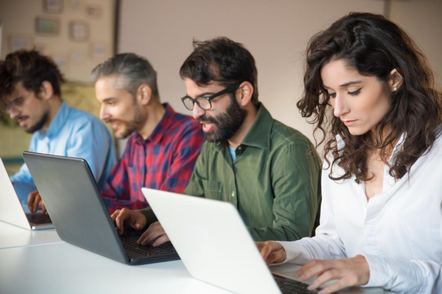 Financial analyst reviewing company data on multiple screens showing charts and spreadsheets